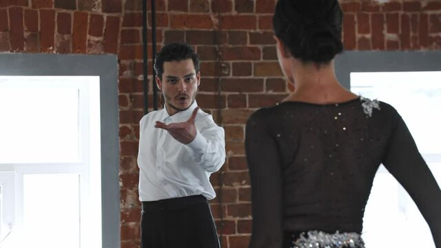 Man and woman practicing elegant pair dance in the studio