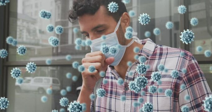 Animation of virus cells and biohazard sign over caucasian man wearing face mask and coughing