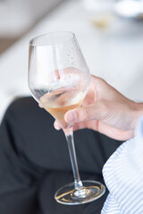 Detail of a male hand aguandanto a glass of white wine