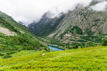 Obraz na płótnie Canvas Beautiful summer panorama of the small mountain lake in Vaujany, France. Cloudy view in the French Alps, Europe. Scenery landscape of high plateau.