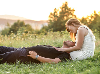 Couple lovers hugging and kissing in the park at sunset. Love, youth, happiness concept.