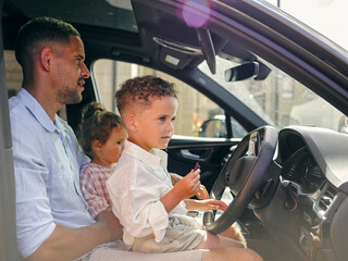 Father with two children sitting in car