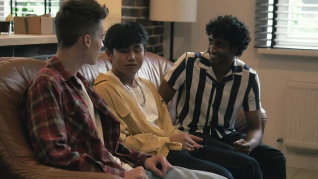 Happy guys talking discussing together. Friends having nice conversation, gossiping. Real man freidnship. Multicultural friendship. Chinese, indian and caucasian men 