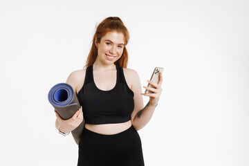 Smiling young plus size fitness woman in sportswear