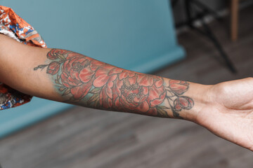 Young black woman showing her tattoo while posing indoors