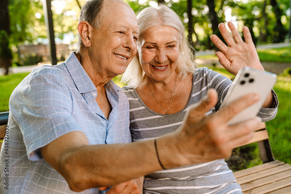 Wall mural happy senior couple with smartphones