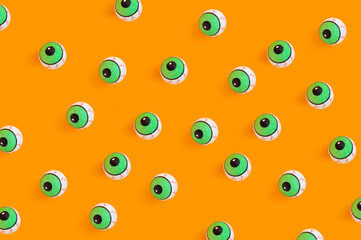 Halloween concept with human doll eyes on orange background
