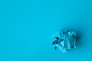 Flat lay composition with crumpled blue paper balls on color background, space for text