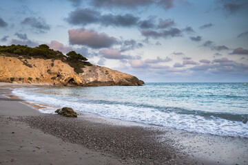 Fototapeta na wymiar Beach and rocky coast with turquoise color sea in Sitges, Spain, Playa del muerto