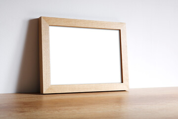 Fototapeta na wymiar Oak photo frame placed on a chest of drawers