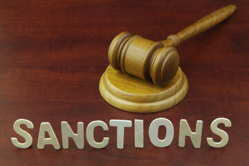 Sanctions, rules and laws concept. Judge gavel and word sanctions on wooden table.