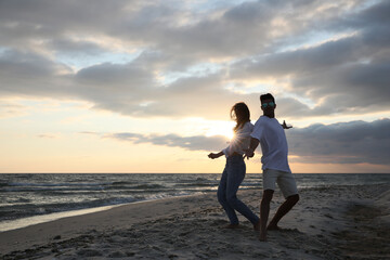 Fototapeta premium Happy couple dancing on beach at sunset