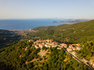 Fototapeta na wymiar Aerial Drone Panorama of mountain old town Marciana on the islands of Elba Italy with green trees and the mediterranean sea ocean in the background