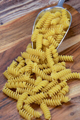 tas de fusilli crues sur un fond en bois