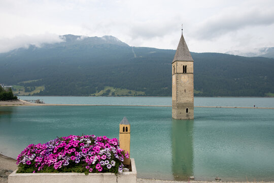 View of the artificial lake of Resia and its submerged bell tower in Curon in the province of Bolzano, Trentino Alto Adige, Italy