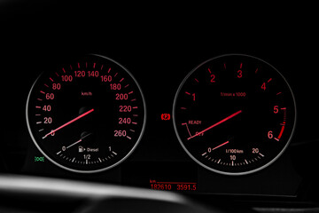 Speedometer arrows with red lights in car.