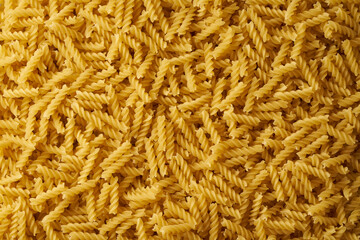 Close-up top view of heap of raw fusilli pasta.