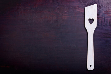 wooden spoon with a heart on a wooden base