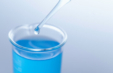 Blue science glass tube experiment on table science copy space.