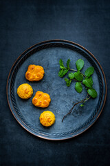 The mooncakes on a plate isolated on  dark gray background. Traditional Chinese Pastry, mid-autumn Moon cake, souffle.