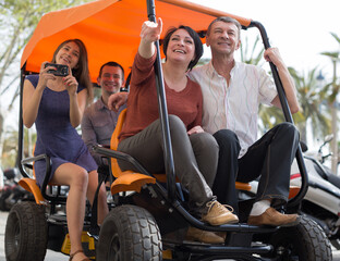 family of tourists enjoy a walk on the bike carriage