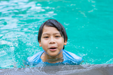 Fototapeta na wymiar Portrait of Asian boy in swimming pool