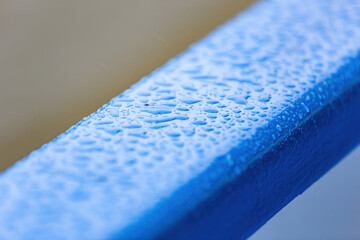 Bright blue surface with water drops and morning dew after rain