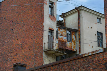 Gloomy inner yards of Vyborg buildings. Rusty drainpipes, old brickwork, windows with bars and...