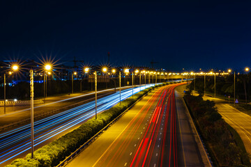 Car light trail on the road at night. Long exposure shot of city light trails captured from Meydan Bridge in Dubai United Arab Emirates.