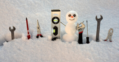 Builder repair tools. Little snowman with repairing instrument. Snow man worker.