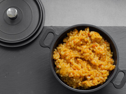 Paella - a Spanish dish originating in Valencia and occurring in many varieties. It is based primarily on rice with the addition of saffron, fried and cooked in a metal pan with two handles.
