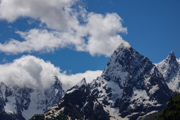 Fototapeta na wymiar Chotcha Mountain Peak Covered with Snow in Teberda Nature Reserve on Clear Sunny Day