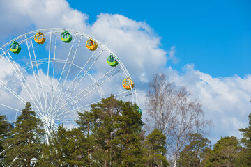Ferris wheel against a clear blue cloudy sky.