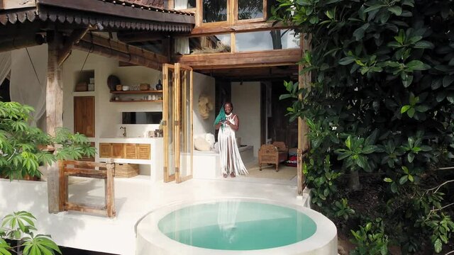 Woman in patio of house surrounded with palms, Bali, Indonesia