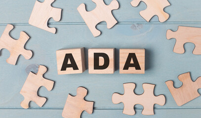 Blank puzzles and wooden cubes with the text ADA Americans with Disabilities Act lie on a light blue background.