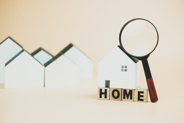 Magnifying glass and white wooden home. Home searching concept. Home appraisal. Property valuation.