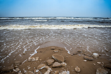 Winter Baltic Sea beach is snowy and there are big waves in the sea