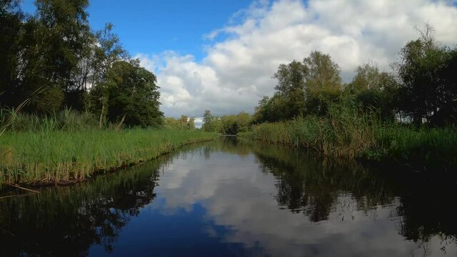 Nature scenery at the Weerribben-Wieden National Park in Overijssel the Netherlands, POV sailing through treed and forest