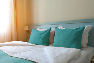 the interior of a small inexpensive hotel room for two persons with double bed. The bed is covered...