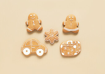 Happy New Year composition, gingerbread man and woman, suitcase and car on beige background.