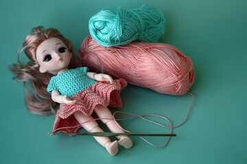 Crochet dress for a small doll made of cotton yarn. Home needlework made of thread.