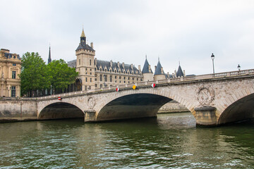 Obraz premium River Traffic underway passing under the Pont au Change bridge Seine River, Conciergerie in the distance, Seine River, 4th arrondissement, Paris, France