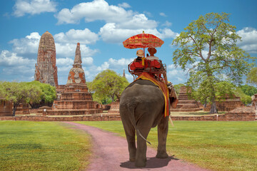 Tourists couple love on a ride elephant tour of the ancient city ayutthaya, thailand - obrazy, fototapety, plakaty