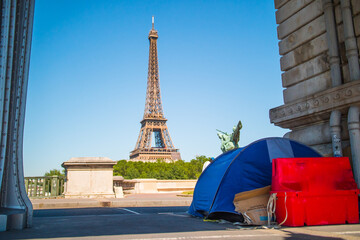 Fototapeta na wymiar Homeless Family Living In A Tent Under Upper Level Of Bir-Hakeim Bridge In Paris, France With Iconic Eiffel Tower In Background.
