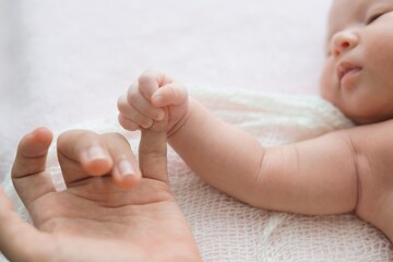 Newborn baby holding fingers parent,Newborn baby sleeping on bed.