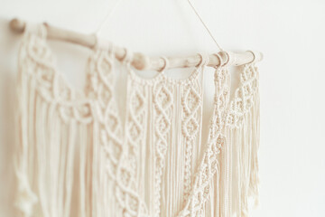 Beautiful boho macrame on wall panel. tapestry in the style of Boho made of cotton threads in natural color using the macrame technique for home decor and wedding decoration. light pastel colors