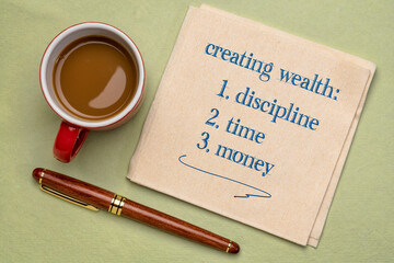 creating wealth - discipline, time and money, handwriting on a napkin with a cup of coffee, investing, retirement and financial concept