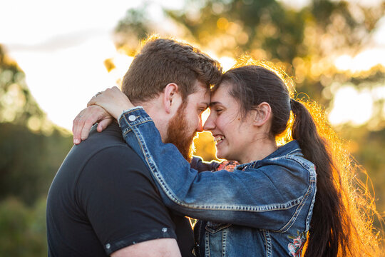 Happy smiling couple in their twenties hug one another