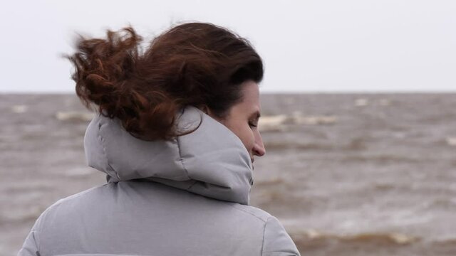 A Woman Looks at the Foamy Waves. Windy Autumn Day at the Shore of Lake Ilmen.