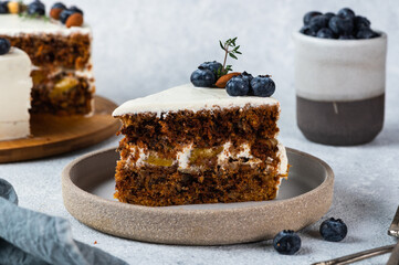 piece of carrot cake with walnuts and blueberry on light background. Local food. Traditional american cake. Cake for thanksgiving day. Autumn cake.